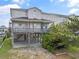 Charming raised beach home with a spacious wooden deck and covered parking with outdoor seating at 48 Sw Wilmington St., Ocean Isle Beach, NC 28469
