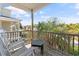 Relaxing covered porch featuring wooden railings and outdoor seating with a view of tropical foliage at 48 Sw Wilmington St., Ocean Isle Beach, NC 28469