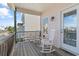 Cozy covered porch with white rocking chairs and a view of neighboring houses and greenery at 48 Sw Wilmington St., Ocean Isle Beach, NC 28469