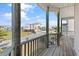 Scenic porch view of the street with houses, palm trees, and parked cars on a sunny day at 48 Sw Wilmington St., Ocean Isle Beach, NC 28469