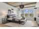 This main bedroom features wooden beams, a modern light fixture, and a window with a beautiful wooded view at 531 Oak Landing Dr., Myrtle Beach, SC 29588