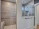 Walk-in shower with gray horizontal tile, glass enclosure, rainfall shower head and shower seat at 531 Oak Landing Dr., Myrtle Beach, SC 29588
