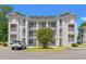 Condo complex featuring white balconies, manicured landscaping, and ample parking at 545 White River Dr. # 15 D, Myrtle Beach, SC 29579