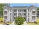 Beautiful condominium complex with multiple units, white pillars, balconies, and lush landscaping at 545 White River Dr. # 15 D, Myrtle Beach, SC 29579