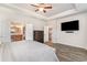 Bright bedroom with TV, wood-look flooring, and ensuite bathroom and walk-in closet access at 567 Hickman St., Surfside Beach, SC 29575