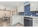 Bright kitchen featuring white cabinets, quartz countertops, modern appliances, and an accent wall of blue subway tile backsplash at 605 62Nd Ave. N, Myrtle Beach, SC 29572