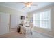 Bright, carpeted home office with a computer desk and built-in cabinets under a ceiling fan at 625 Whispering Pines Ct., Murrells Inlet, SC 29576
