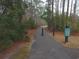 A tranquil walking path through a wooded area provides residents with a serene space for recreation at 625 Whispering Pines Ct., Murrells Inlet, SC 29576