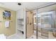 Bathroom with storage cabinets, open shelving and a shower featuring grab bars and sliding glass door at 645 Retreat Beach Circle # A-2-C, Pawleys Island, SC 29585