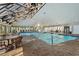 Bright indoor pool area featuring a vaulted ceiling, exposed beams, and brick surround at 645 Retreat Beach Circle # A-2-C, Pawleys Island, SC 29585