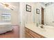 Bright bathroom with a single sink vanity, view to bedroom, and colorful wallpaper at 665 Tupelo Ln. # 17-F, Longs, SC 29568