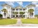 Three-story condo building with white siding, multiple balconies, and beautiful landscaping with palm trees at 665 Tupelo Ln. # 17-F, Longs, SC 29568