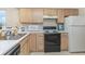 Kitchen with light wood cabinets, white countertops, and standard appliances including microwave and stove at 665 Tupelo Ln. # 17-F, Longs, SC 29568