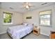 Cozy bedroom with a ceiling fan, two windows providing natural light, and soft bedding at 703 S 21St Ave. S, North Myrtle Beach, SC 29582