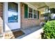 Close-up view of the brick porch with green shutters and a welcoming 'Welcome' mat at 703 S 21St Ave. S, North Myrtle Beach, SC 29582
