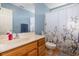 Bright bathroom features a single sink vanity with oak cabinets and a white shower curtain with colorful floral print at 706 Chippendale Dr., Myrtle Beach, SC 29588