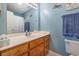 Cozy bathroom featuring an oak vanity, a large mirror, and blue walls at 706 Chippendale Dr., Myrtle Beach, SC 29588