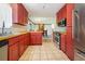 Open kitchen showcasing red cabinetry, a stainless steel dishwasher, and a view to the dining area at 706 Chippendale Dr., Myrtle Beach, SC 29588