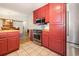 Kitchen featuring red cabinets, stainless steel appliances, and view to the dining area at 706 Chippendale Dr., Myrtle Beach, SC 29588