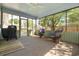 View of screened-in porch featuring comfortable wicker furniture, ceiling fan, and outdoor grill for entertaining at 706 Chippendale Dr., Myrtle Beach, SC 29588