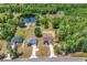 Aerial view of three homes and the surrounding lush green trees and a large pond at 718 Highway 348, Loris, SC 29569