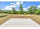 Spacious backyard with a concrete patio offering a view of the lush green trees and pond at 718 Highway 348, Loris, SC 29569