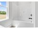 Clean white bathroom with a bathtub and shower combination and bright window views at 718 Highway 348, Loris, SC 29569
