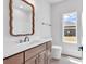 Bathroom with wood vanity, white countertop, toilet, and natural lighting at 718 Highway 348, Loris, SC 29569