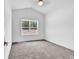 Empty bedroom with plush gray carpet and a window overlooking a treed backyard at 718 Highway 348, Loris, SC 29569