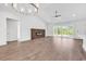 Spacious living room with wood floors, modern light fixtures, a fireplace, and natural light at 718 Highway 348, Loris, SC 29569