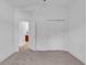 Bright bedroom featuring neutral carpet, white trim, a double closet, and an open door to another room at 722 Highway 348, Loris, SC 29569