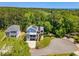 Aerial view of a charming home with solar panels, a three-car garage, and picturesque landscaping at 77 Streater Ln., Pawleys Island, SC 29585