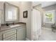 Bright bathroom with granite countertop vanity and shower-tub combo with stylish shower curtain at 77 Streater Ln., Pawleys Island, SC 29585