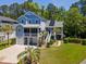 Exterior elevation of a charming two-story home with a three-car garage, solar panels and well-manicured lawn at 77 Streater Ln., Pawleys Island, SC 29585