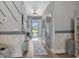 Inviting foyer with a decorative accent wall, hardwood floors and an open door at 804 Twickenham Loop, Longs, SC 29568
