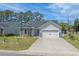 Charming home featuring stone accents, manicured lawn, and an attached two-car garage at 804 Twickenham Loop, Longs, SC 29568