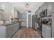 Spacious kitchen featuring gray cabinetry, stainless steel appliances, granite countertops, and wood flooring at 804 Twickenham Loop, Longs, SC 29568