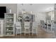 Modern kitchen with gray cabinets, granite counters, stylish lighting, and bar seating overlooks a dining area at 804 Twickenham Loop, Longs, SC 29568