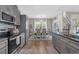 Kitchen with gray cabinetry, granite countertops, stainless steel appliances, and an adjacent dining area at 804 Twickenham Loop, Longs, SC 29568
