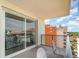 Relax on this condo's balcony offering comfortable seating and views of nearby buildings and a blue sky with fluffy white clouds at 8121 Amalfi Pl. # 4-801, Myrtle Beach, SC 29572