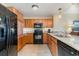 Well-equipped kitchen featuring wooden cabinets, granite countertops, and black appliances at 8121 Amalfi Pl. # 4-801, Myrtle Beach, SC 29572