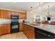 Modern kitchen with granite countertops, wooden cabinets, and black appliances at 8121 Amalfi Pl. # 4-801, Myrtle Beach, SC 29572
