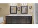Bathroom with double vanity, dark wood cabinets, and framed mirrors with decorative sconces at 813 Bear Lake Dr., Longs, SC 29568