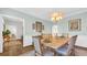 Another angle of the dining room with wooden table, neutral chairs, and decorative wall art at 813 Bear Lake Dr., Longs, SC 29568