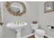 Charming powder room featuring a pedestal sink, round gold mirror, and decorative accents at 813 Bear Lake Dr., Longs, SC 29568