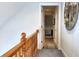 Upstairs hallway with hardwood railing overlooking the lower level. View of open doorway and patterned floor mat at 813 Bear Lake Dr., Longs, SC 29568