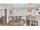 Eat-in kitchen features wooden floors, a glass table, and white cabinets with granite countertops at 813 Bear Lake Dr., Longs, SC 29568