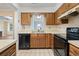 Cozy kitchen featuring wood cabinets, black appliances, and a window above the sink providing natural light at 88 Purple Martin Dr., Murrells Inlet, SC 29576