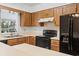 Traditional kitchen with wood cabinetry, black appliances, and a breakfast bar for casual dining at 88 Purple Martin Dr., Murrells Inlet, SC 29576