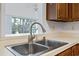 Close-up of the kitchen sink featuring a modern faucet, stainless steel basin, and window view at 88 Purple Martin Dr., Murrells Inlet, SC 29576